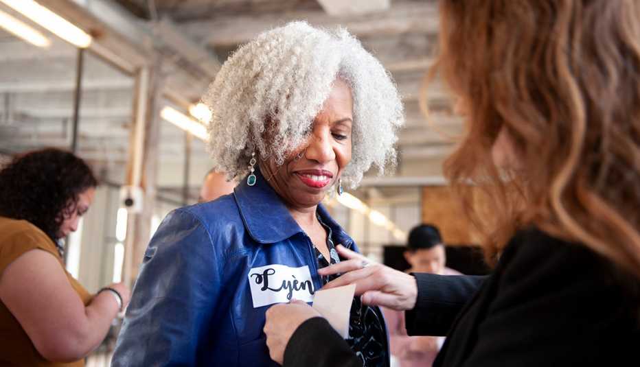 an employee is given a name tag an employee in a blue jacket receives a new name tag