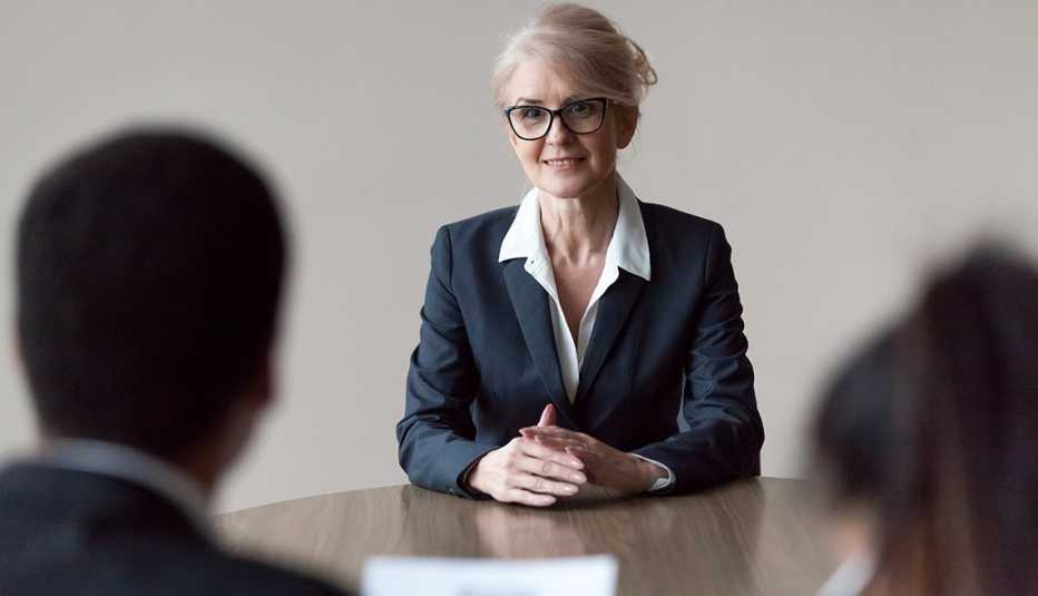 A smiling female job applicant is being interviewed by two young employees