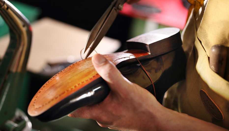 a shoe repairman's hands working on a shoe