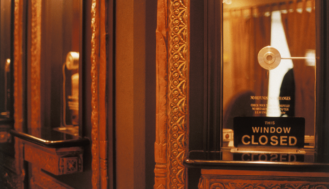 an empty theater ticket booth with a closed sign in the window