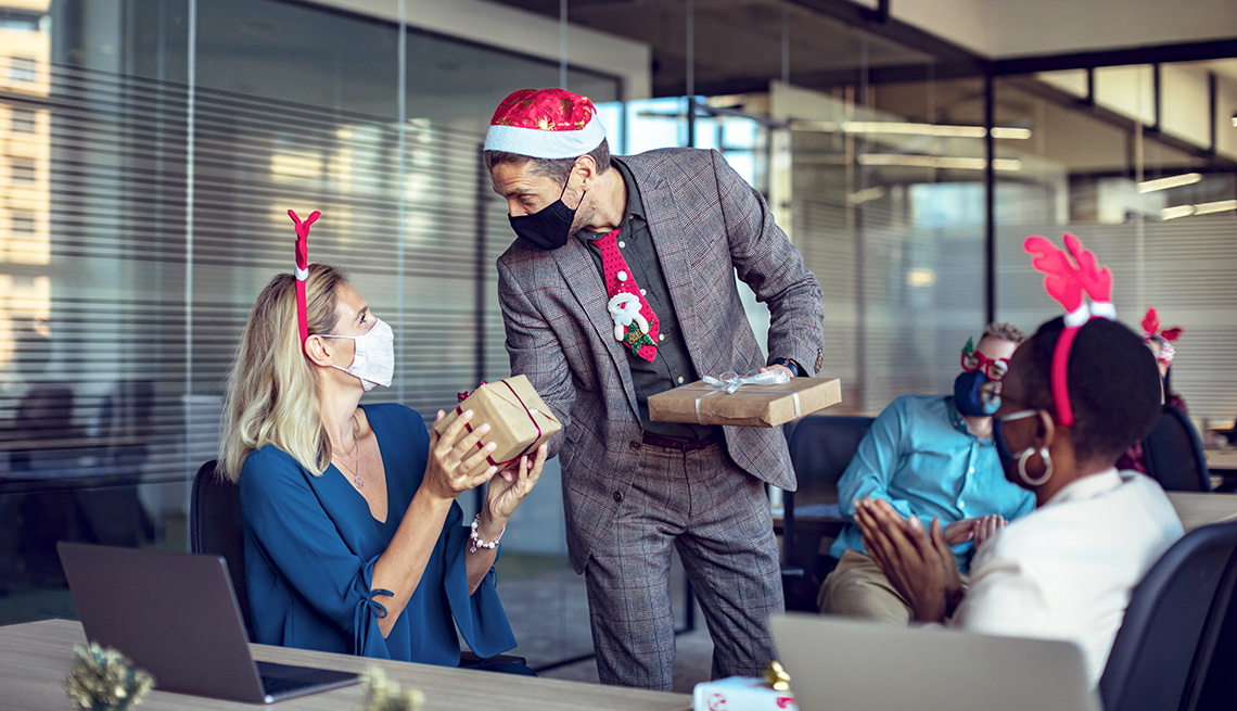 People giving out gifts at an office holiday party