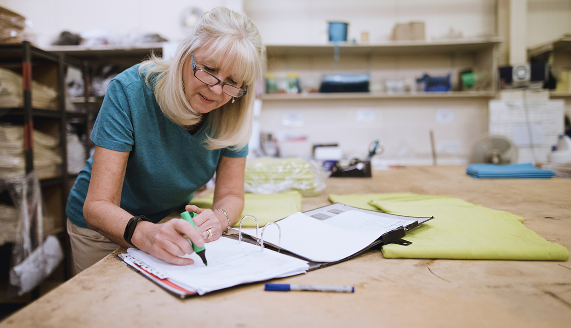 A woman working on paper work at her desk