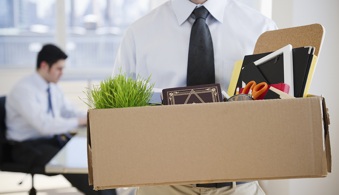 a man holding a box of office supplies