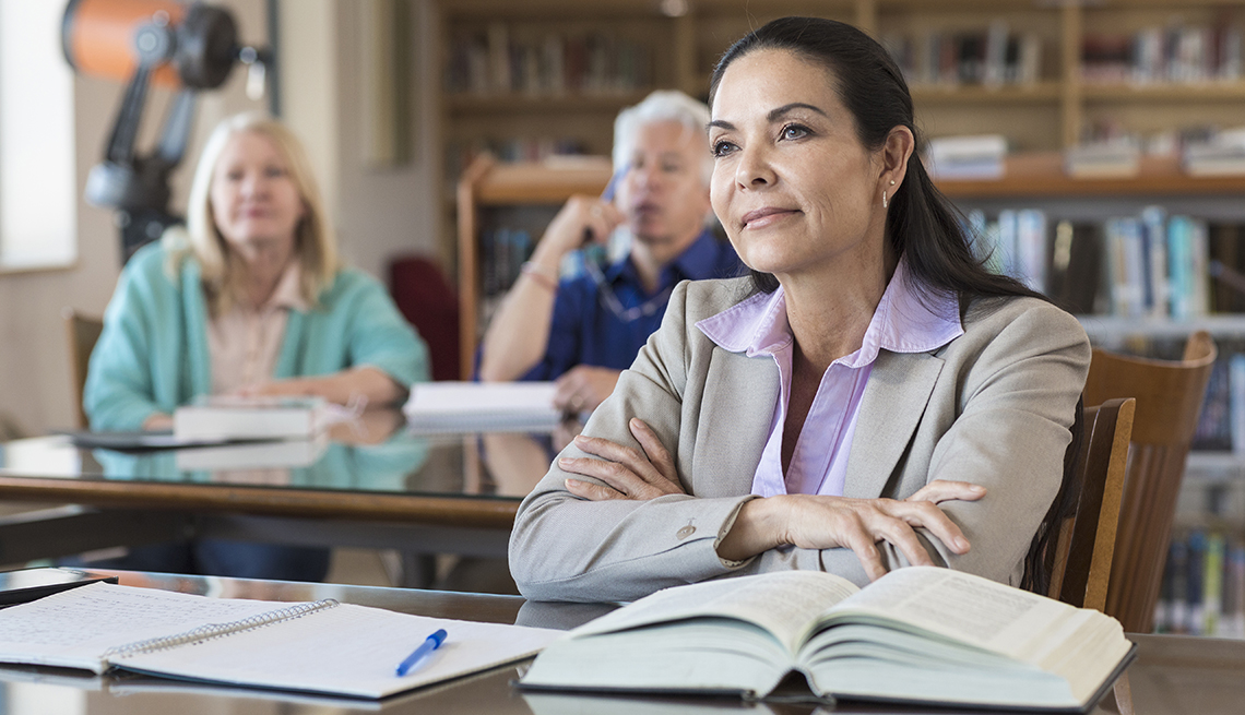 Mature Woman in Library, Book Open, Notebook Ready, Scholarships for Midlifers