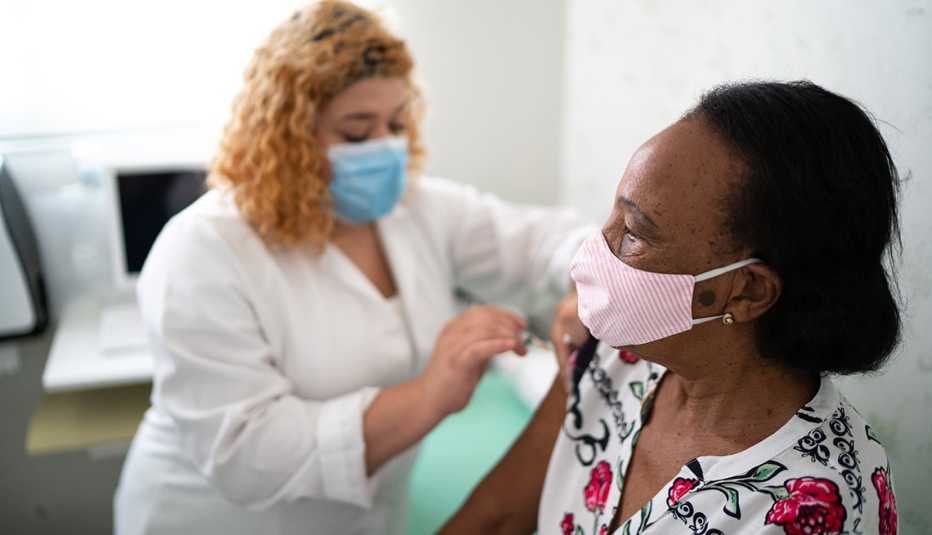 A nurse is giving a woman a vaccine A nurse is giving a woman a vaccine