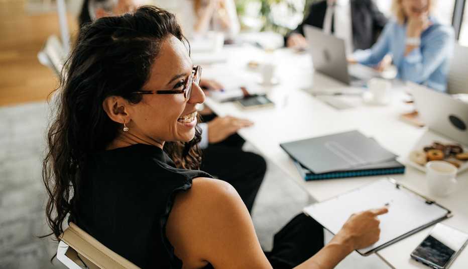 a female employee smiles while sitting in a meeting at work