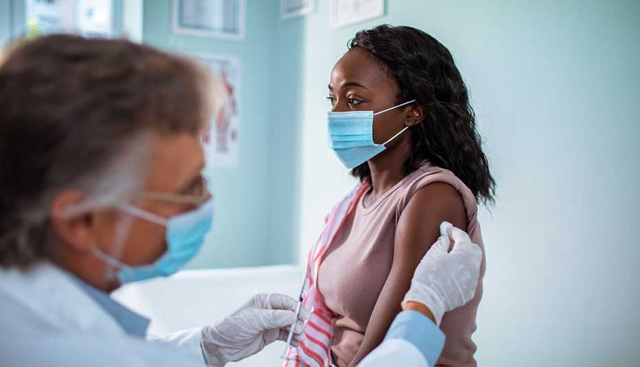 Women is getting a shot in the arm from a doctor