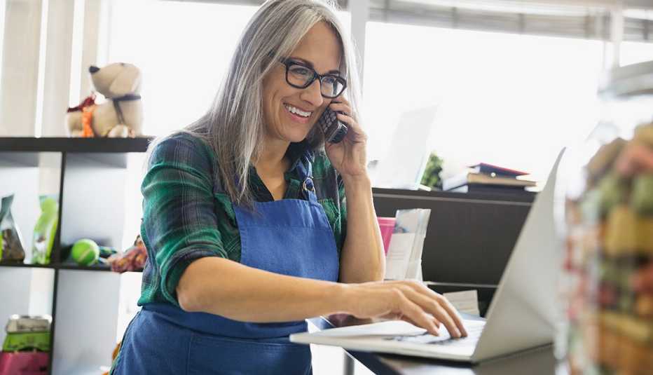 Woman working on a computer while talking on the phone