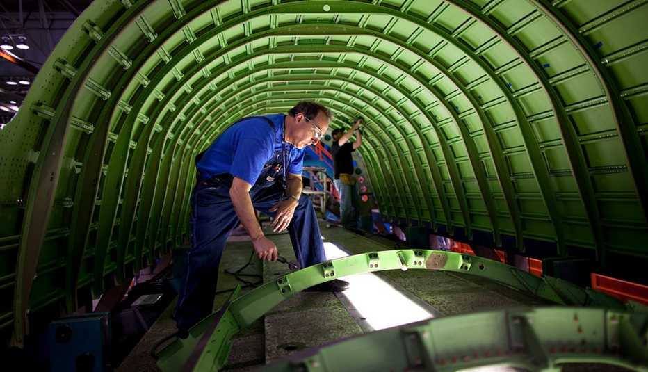 A worker helping to build an airplane