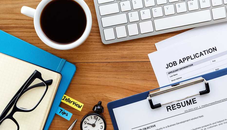 An application and resume sit on a desk with coffee and a keyboard