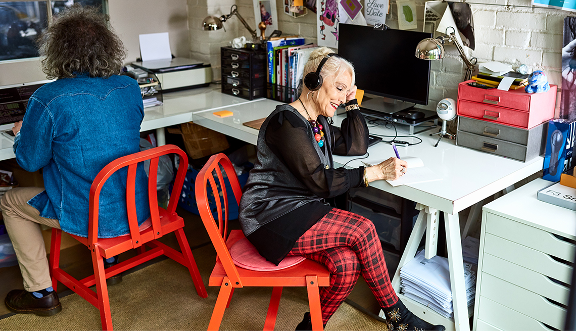 A woman at work sitting at a desk wearing headphones listening to a customer service call