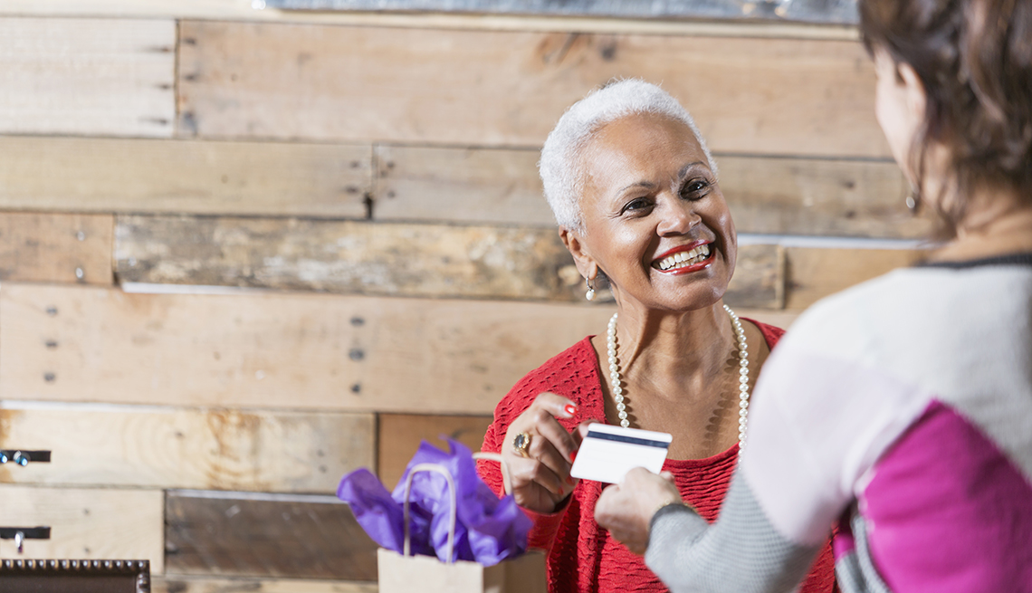 A cashier is taking the credit card of a customer at a store