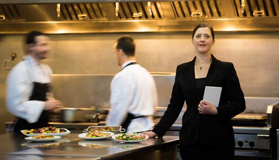 a food service manager with two kitchen workers behind her