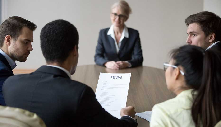 a group of people sitting around a table during a job interview
