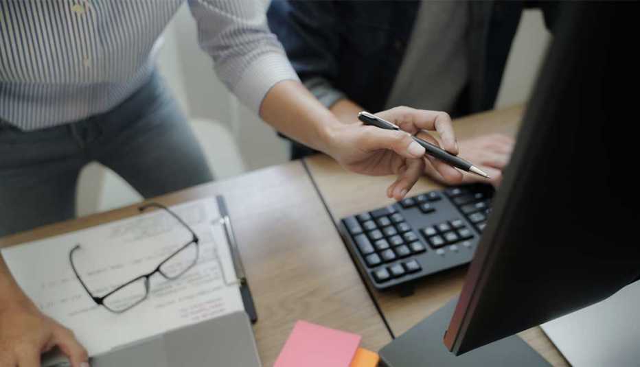 A woman pointing something out on a computer screen