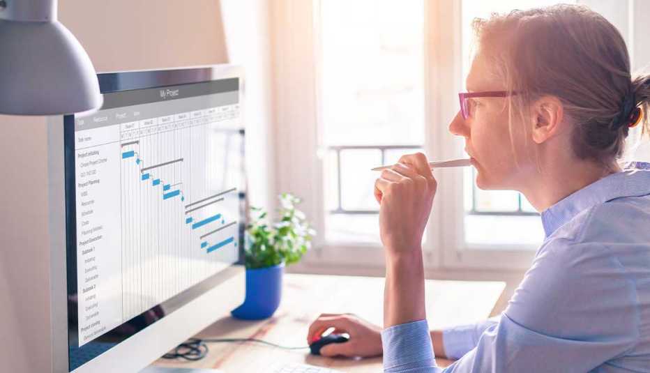 A woman sitting at a desk looking at a screen