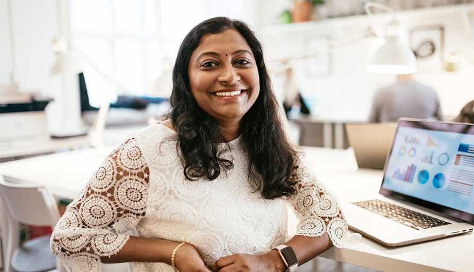 A woman smiling while sitting at a desk