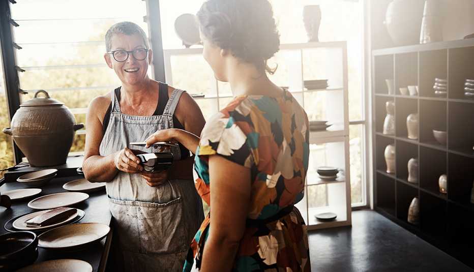a business owner sells her pottery to a customer
