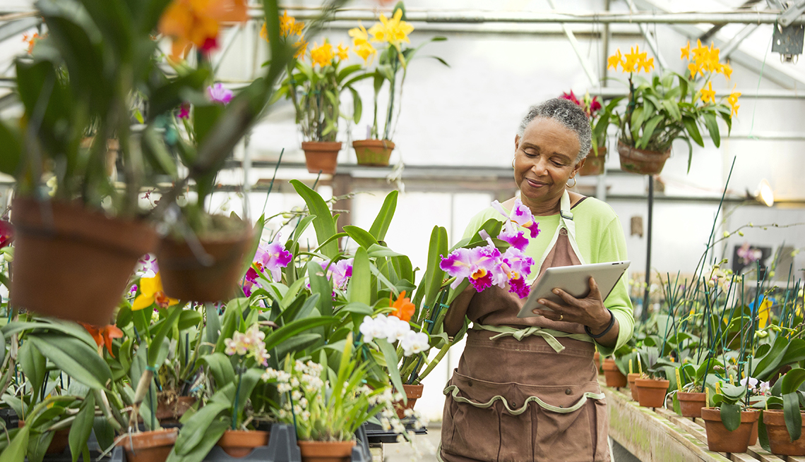 a woman holding a tablet surrounded by plants