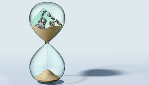 un reloj de arena con una declaracion de impuestos