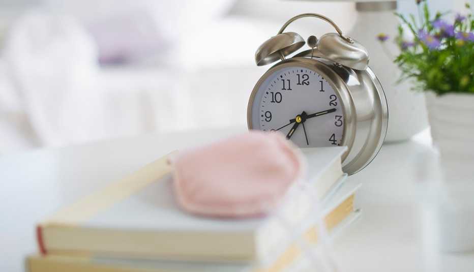 Reloj despertador sobre una mesa de noche