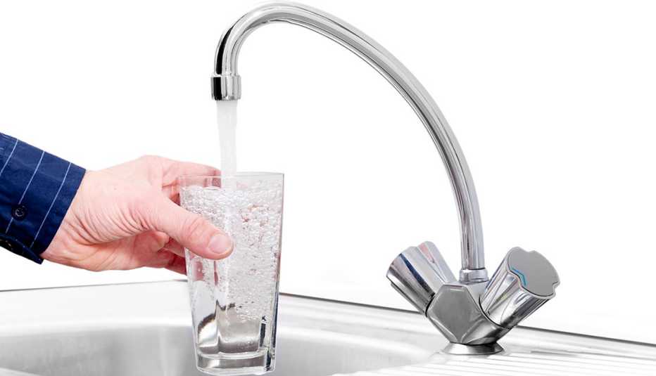 Un hombre sirve agua de la llave