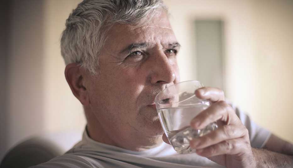 Un hombre toma agua de un vaso