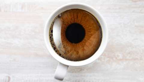 Iris de un ojo dentro de una taza de café Iris de un ojo dentro de una taza de café