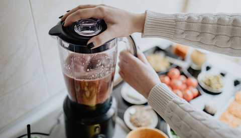 Una mujer se prepara un batido de desayuno