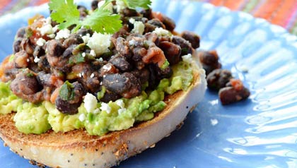 Plato con bagel, guacamole y frijoles negros