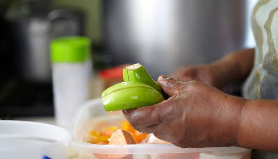 Una persona le quita la cáscara a unos plátanos verdes