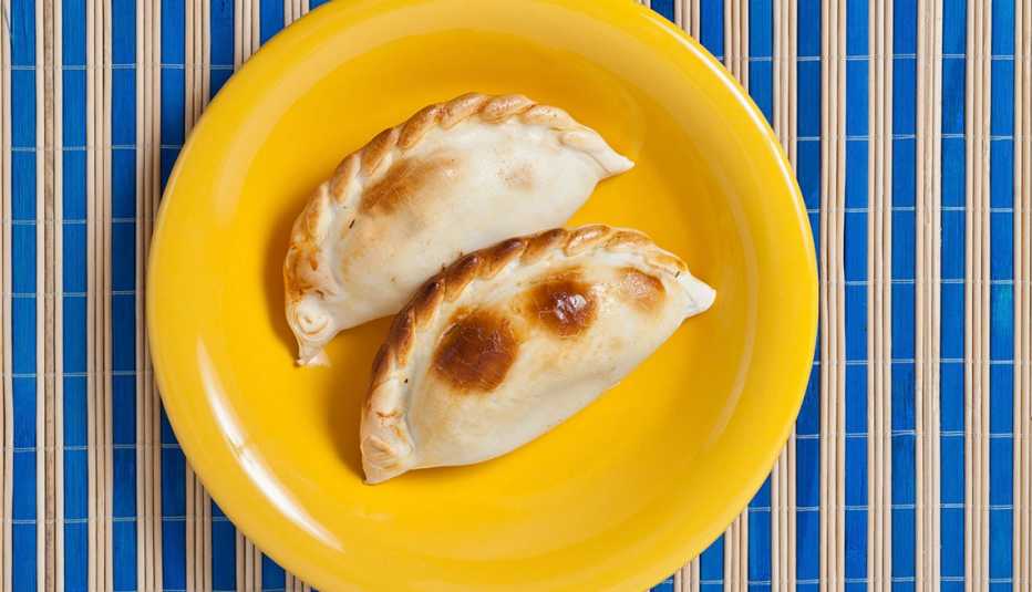 Dos empanadas en un plato amarillo