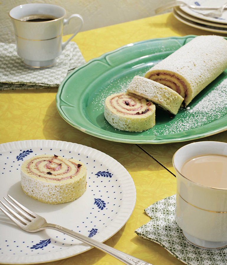 Brazo gitano servido y café sobre una mesa