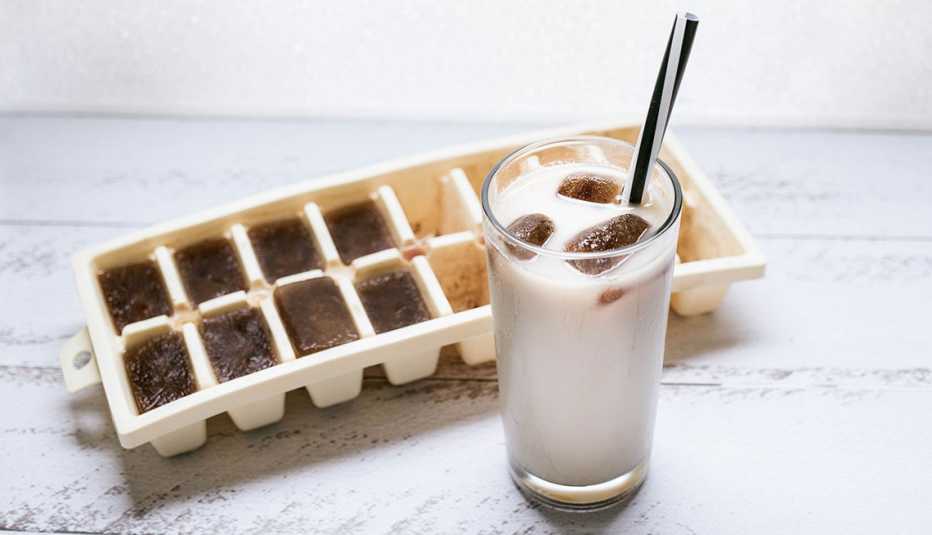 Cubetas de hielo con café y vaso de leche