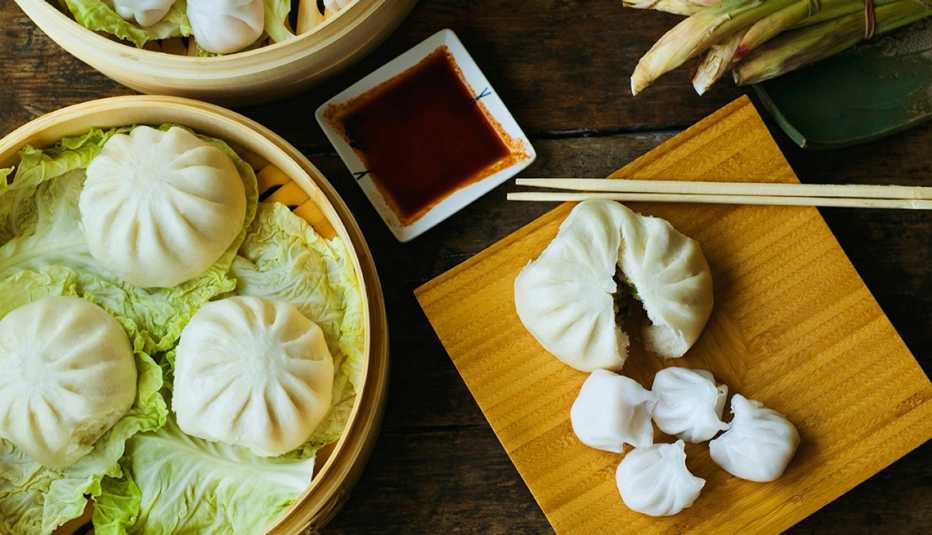 Overhead Shot Of Dim Sum, Chinese Food, Dumplings, AARP Food And Recipes, Authentic Asian Dishes Asian dumpling in steamer with cabbage.