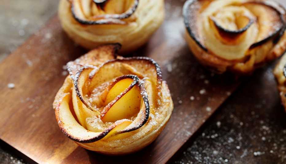 Rosas de manzana bañadas en dulce de leche sobre una mesa Rosas de manzana bañadas en dulce de leche sobre una mesa