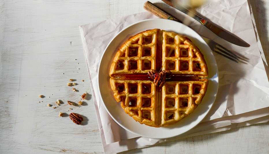 Waffle en un plato con jarabe y pacanas Waffle en un plato con jarabe y pacanas