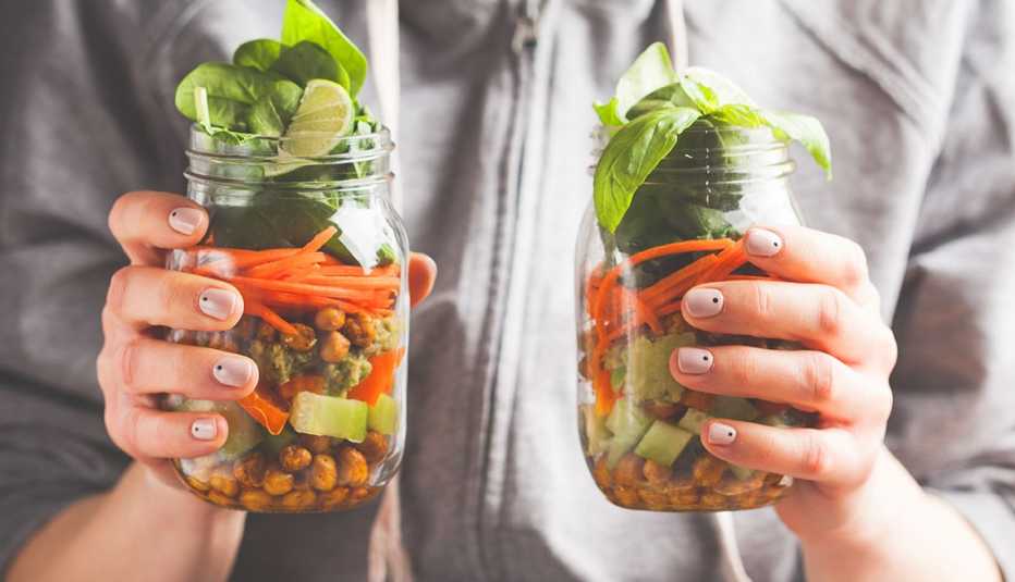 Mujer con dos frascos con ensalada