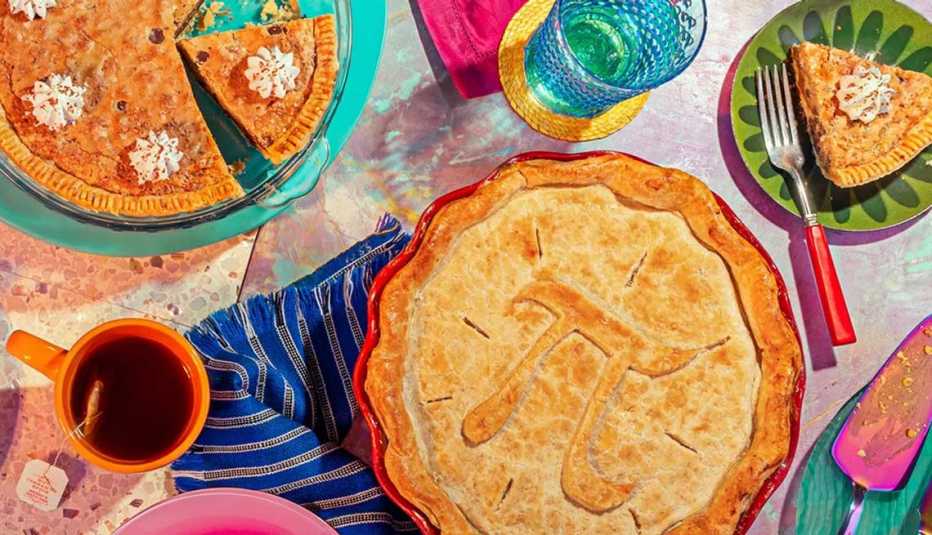 Mesa servida con varios pasteles y uno tiene como diseño el símbolo de Pi 