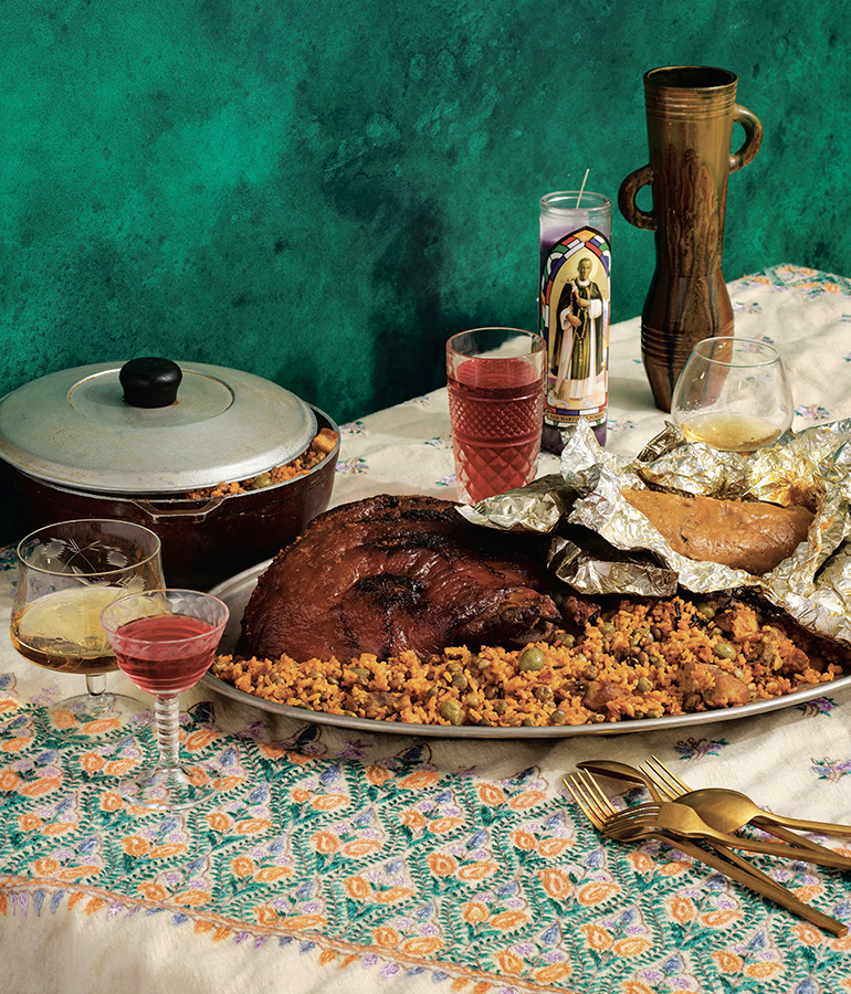 Mesa servida con arroz con gandules, pernil y varias bebidas