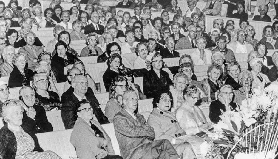 Grupo de gente dentro el público, sentado y poniendo atención a lo que sucede en el escenario.