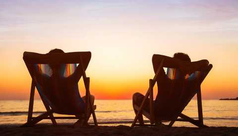 pareja feliz relajandose en la playa al atardecer en un destino paradisiaco pareja feliz relajandose en la playa al atardecer en un destino paradisiaco