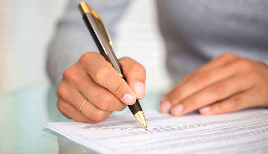 Manos de una mujer firmando un contrato... cuidado cuando eres codeudor de un préstamo Manos de una mujer firmando un contrato... cuidado cuando eres codeudor de un préstamo