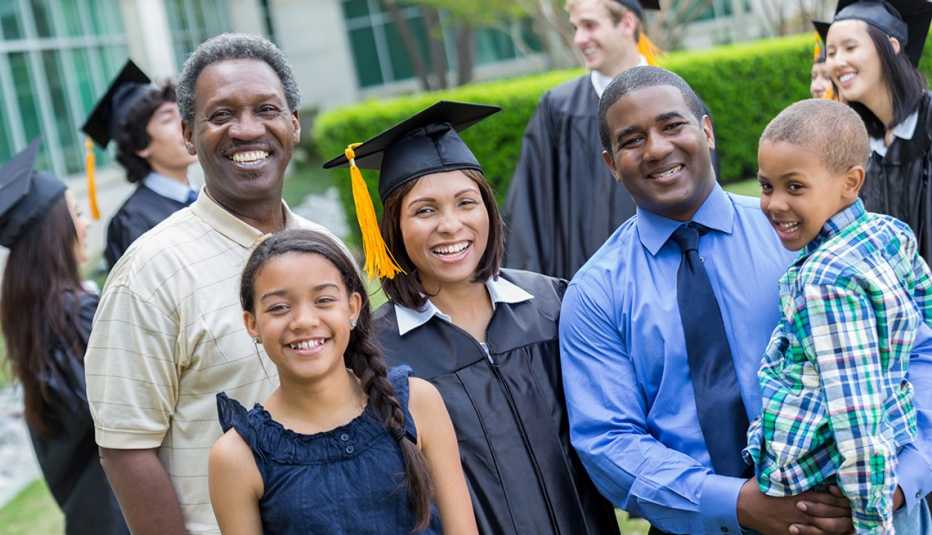 Mujer el día de su grado, con su esposo, sus hijos y su padre.