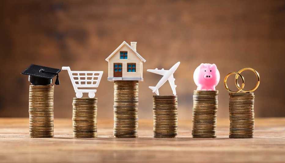 6 columnas de monedas apiladas y encima un birrete, un carrito de compras, una casa, un avión, una alcancía, y unos anillos 6 columnas de monedas apiladas y encima un birrete, un carrito de compras, una casa, un avión, una alcancía, y unos anillos