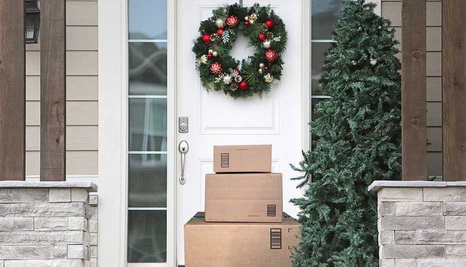 Entrada a una casa y la puerta decorada de navidad con paquetes recibidos por correo