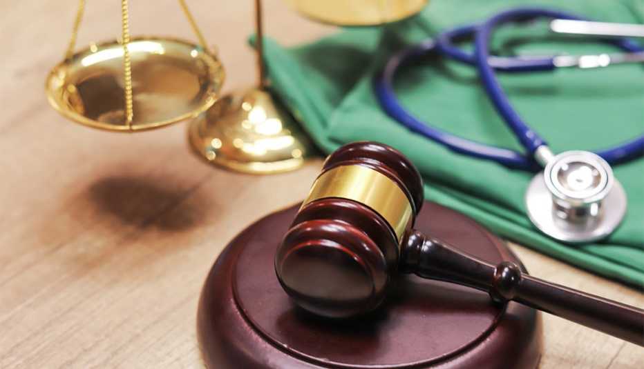 Mazo de una corte de justicia al lado de un estetoscopio y una balanza Mazo de una corte de justicia al lado de un estetoscopio y una balanza