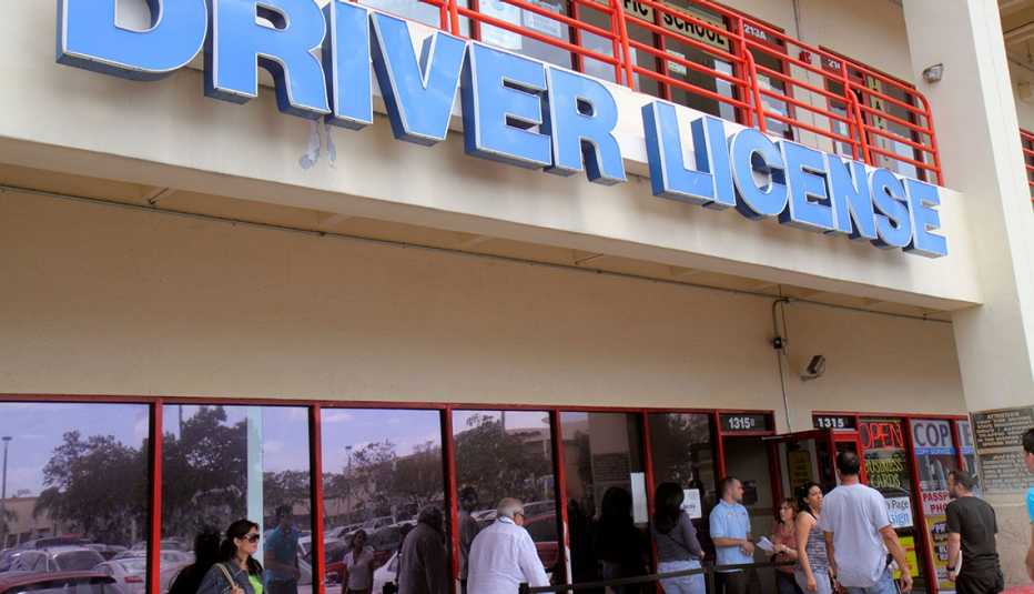 Personas haciendo fila a la entrada de una oficina del Departamento de Vehículos motorizados