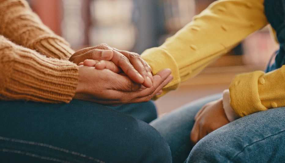 Una persona sostiene la mano de otra en señal de apoyo Una persona sostiene la mano de otra en señal de apoyo