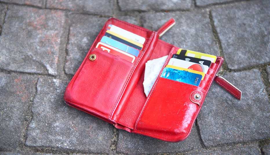Billetera roja abierta y tirada en el suelo con todas las tarjetas